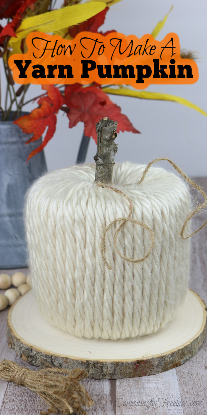 Finished yarn pumpkin with fall leaves in watering can in background and woods beads to the side. Text overlay at top that says How To Make A Yarn Pumpkin