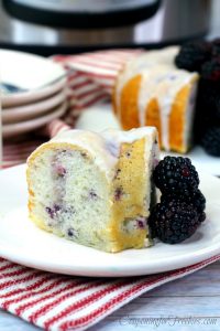 Slice of blackberry bundt cake on white plate with Instant Pot in background