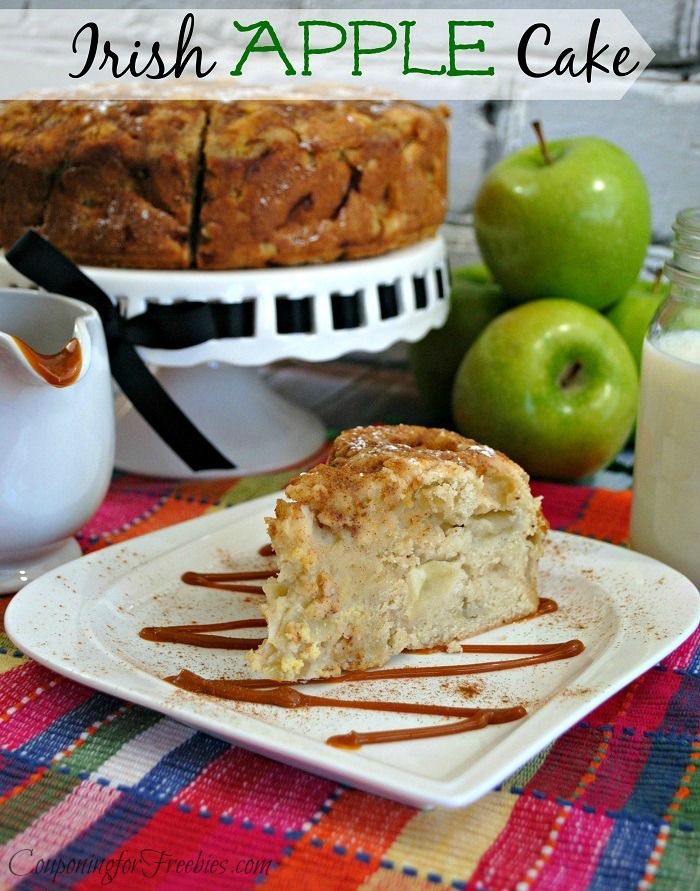Slice of Irish Apple Cake on white plate with whole cake in background with green apples.