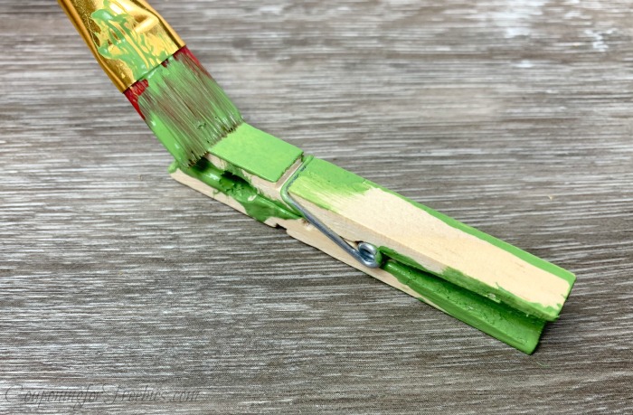 Painting a wood clothespin green